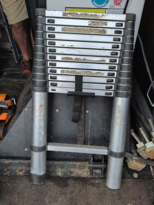 un homme debout à côté d'une pile d'outils métalliques