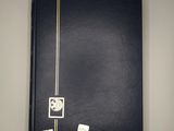 a black book sitting on top of a table next to a white wall