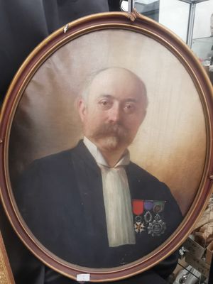 portrait d'un homme en costume-cravate tenant une photo encadrée de lui-même