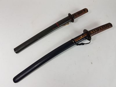 deux sabres de samouraï posés sur une surface blanche, avec un manche noir
