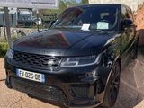 a black range rover parked in front of a large sign
