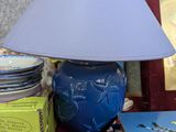 une lampe posée sur une table à côté d'une pile de livres