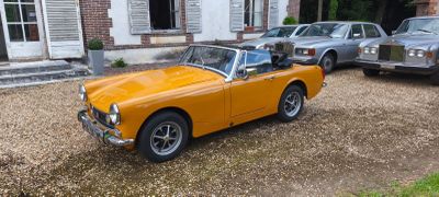 deux voitures garées devant une maison, avec une voiture dans l'allée