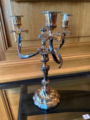 un chandelier en argent posé sur une table en verre dans une pièce