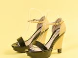 sandales à talons hauts noires et blanches avec des lanières transparentes, sur fond jaune