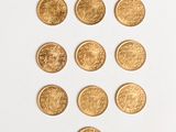 a close up of a bunch of gold coins on a white surface