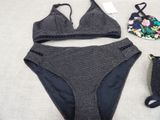 a bikini top and panties on a bed next to a purse