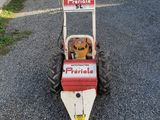 a red and white lawn mower sitting on the ground