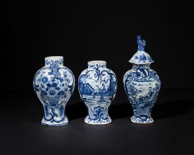 three blue and white vases sitting next to each other on a black surface