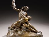 a bronze statue of a woman and a man sitting on a rock