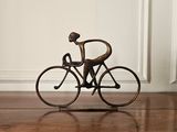 une statue en bronze représentant un homme à vélo