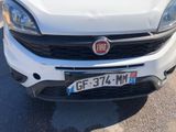 the front end of a white car parked in a parking lot