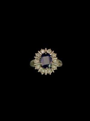 gros plan d'une bague avec une pierre bleue entourée de diamants