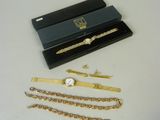 a black box with a gold chain bracelet and a watch