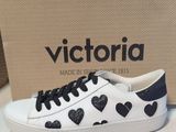 white and black sneakers with black hearts on them sitting on a table