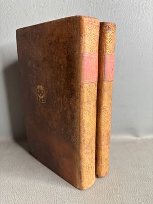 un vieux livre posé sur une table à côté d'un mur blanc