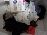 a white bag full of clothes and a toilet paper