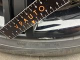 a ruler on the rim of a car that is parked on the street