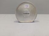 a small silver object on a table with a sticker on it
