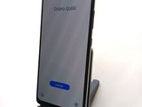a close up of a cell phone on a stand on a white surface