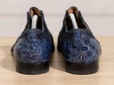 the blue shoes are lined up on a wooden surface