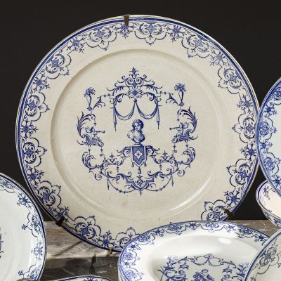 several blue and white plates with a monogram on them on a table