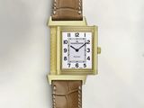 une image d'une montre en or avec un bracelet en cuir marron