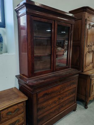 une armoire en bois avec une porte vitrée, à côté d'une commode