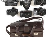 de nombreux types d'appareils photo et un sac posés sur la table