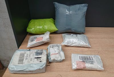 many bags of items on a table with a pillow