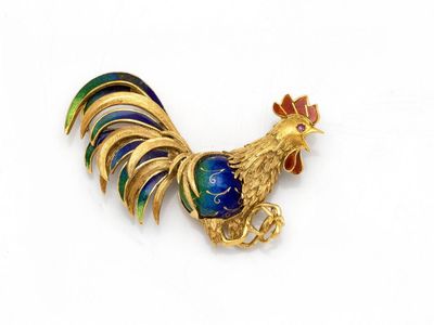 une image représentant une broche en forme de coq, en or et émail, sur fond blanc