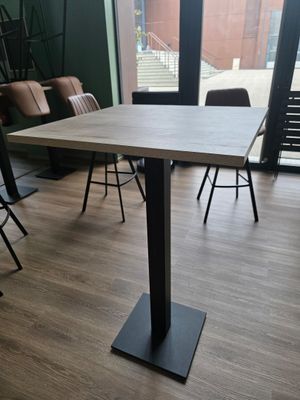 des tables et des chaises dans une pièce avec une grande fenêtre en arrière-plan