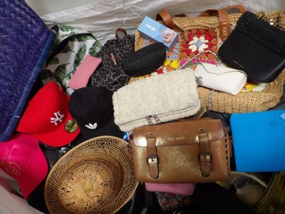 beaucoup de sacs à main, de chapeaux et d'autres objets dans un bac