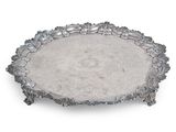 un plateau ovale en argent orné de fleurs et de feuilles sur le bord