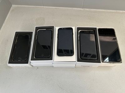 Quatre iPhones sont alignés sur une surface blanche