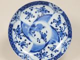 assiette bleue et blanche ornée d'un motif représentant un oiseau et une fleur