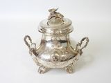 a silver teapot with a lid on a white surface