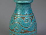a blue vase with gold designs on it on a gray surface