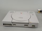 a white game console with a game controller attached to it