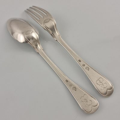 two spoons and a fork sitting on a table