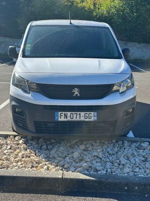 une petite camionnette blanche garée dans un parking