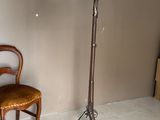 une lampe posée sur un pied à côté d'une chaise