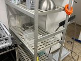 une cuisine équipée d'une cuisinière, d'un évier et d'une étagère en métal