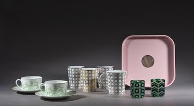 de nombreuses tasses et soucoupes posées sur une table à côté d'un plateau