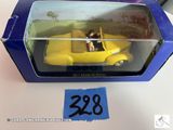 une petite voiture jaune dans une boîte bleue posée sur une table