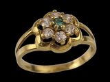 a close up of a gold ring with green and white stones