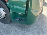 a close up of a green semi truck with its door open