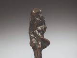une photo d'une statue en bronze représentant un homme assis sur un rocher
