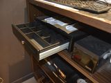 a computer desk with a keyboard and a drawer in front of it