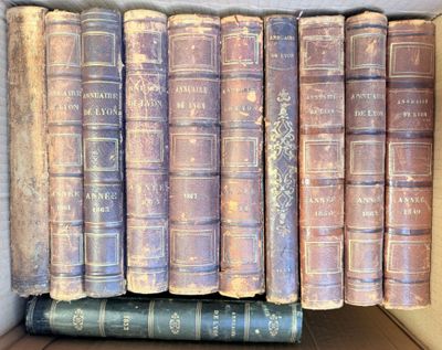 several old books are stacked on top of each other in a box